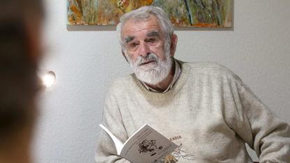 Petrus Ceelen, sitzend, im Gespräch, mit Buch in der Hand